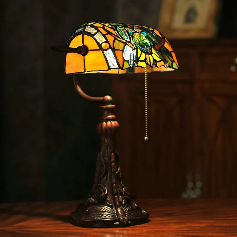 Tiffany table lamp with stained glass shade on wooden desk, 36cm tall with warm lighting