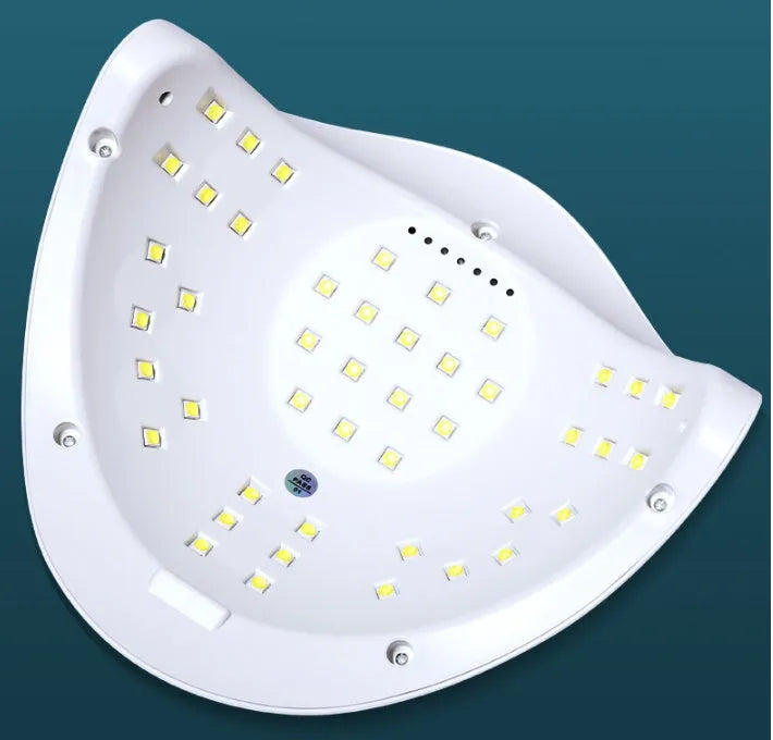 White nail polish quick-drying baking lamp dryer with dual UV and LED light sources on a clean surface.