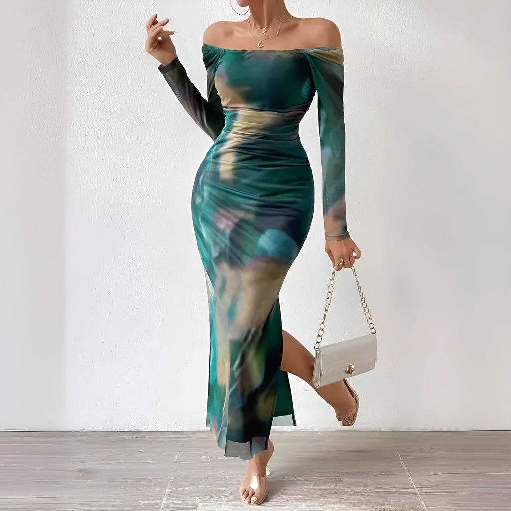 A woman wearing a long green mesh fishtail dress with pleats, a square collar, and a gradient colour print.