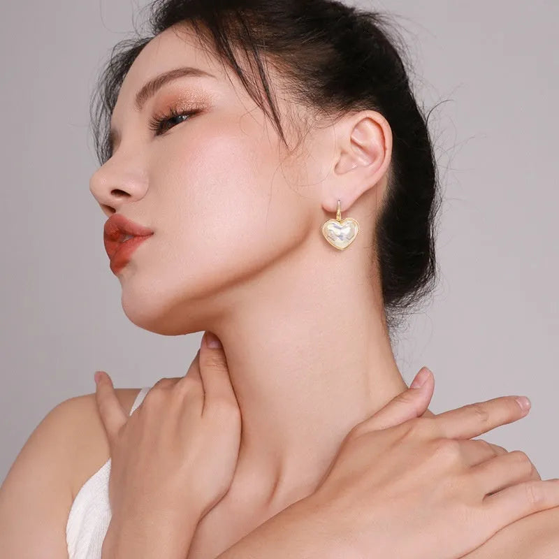 A pair of gold-coloured clip-on earrings with a metallic finish and natural styling.