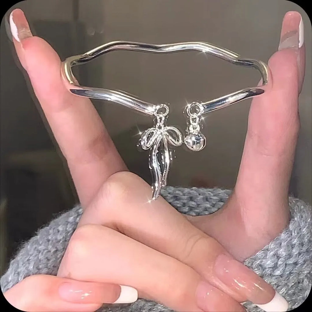 Silver adjustable bow bracelet with bell opening mechanism on zinc alloy chain