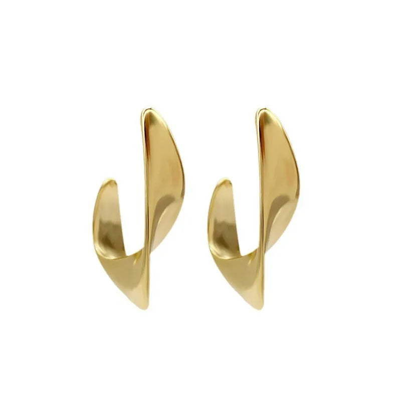 Gold and silver twisted geometric metal earrings with a round design element.