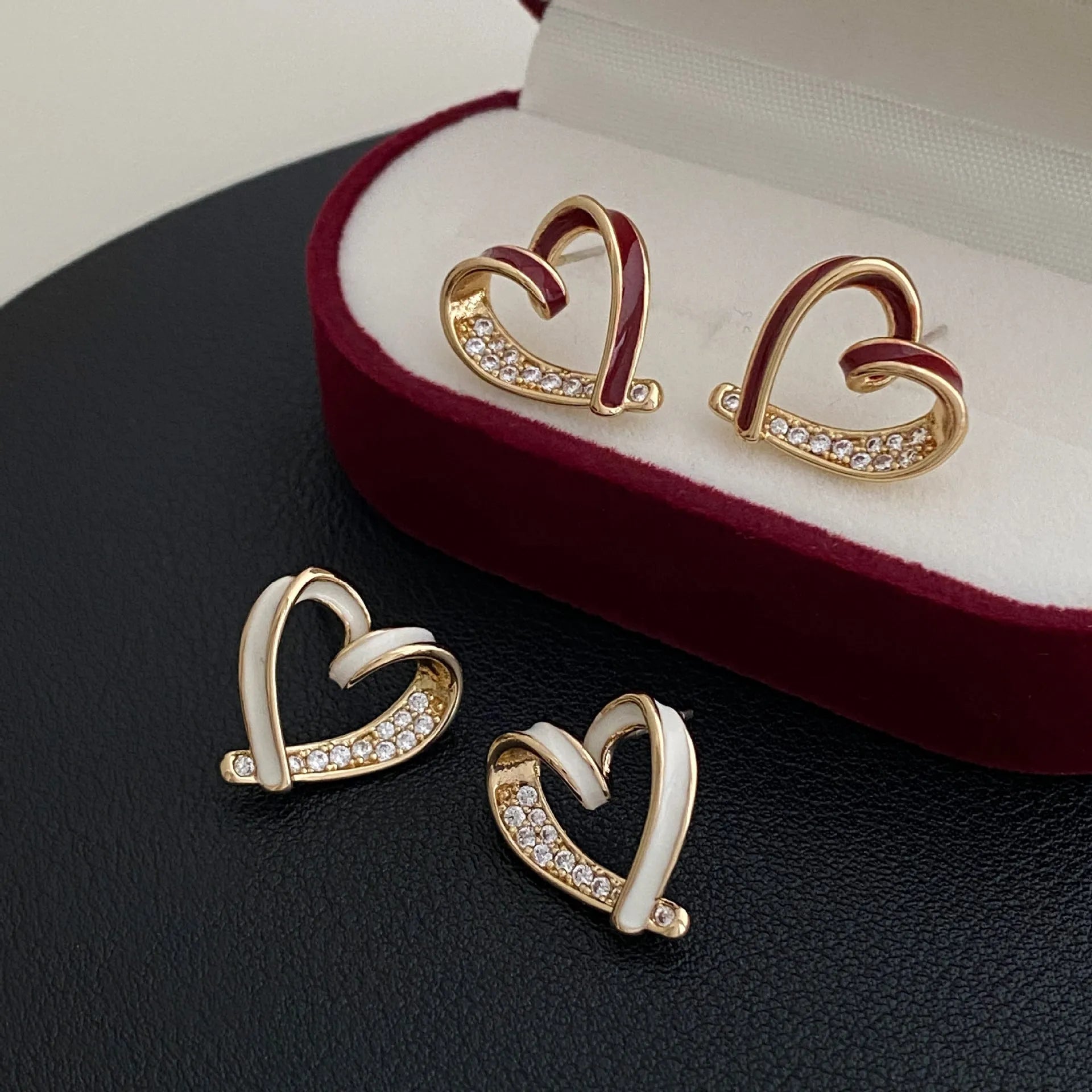 Fashion micro-set zircon asymmetric earrings in copper heart shape with love motif, available in red or white as ear clips or studs