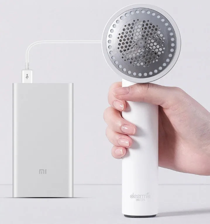 White rechargeable lint remover with three blades, hidden collection container, and ABS build on a plain background