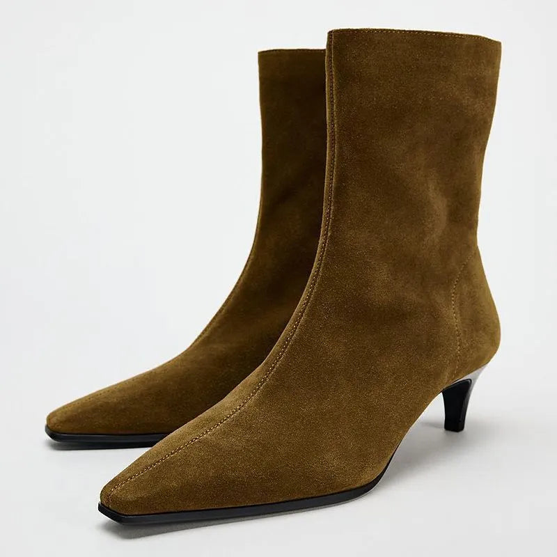 Brown square toe women's boots with a side zipper and a mid stiletto heel on a wooden floor.