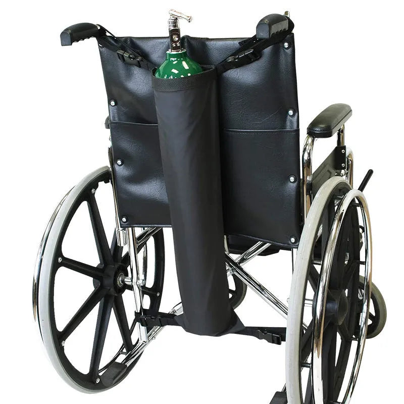 Black cylindrical pannier bag for an oxygen cylinder attached to a wheelchair.