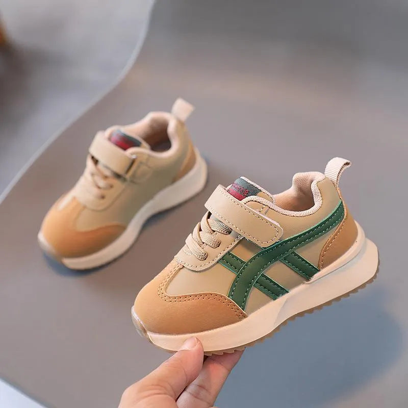 Children's white synthetic leather sneaker with Velcro strap and rubber sole.