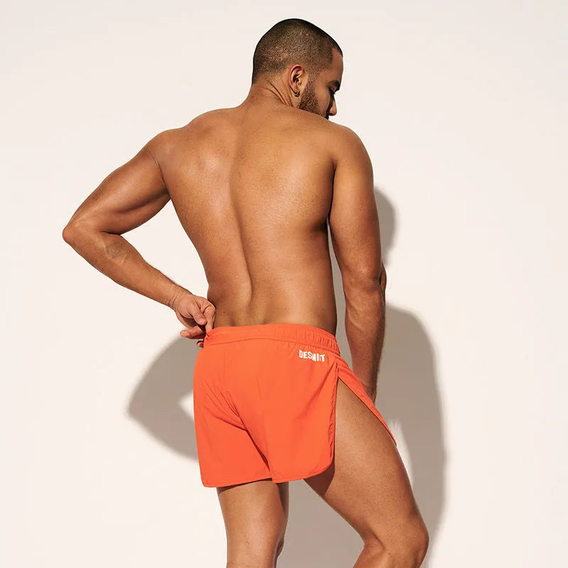 Men's loose polyester beach shorts in black, fluorescent green and orange red colours