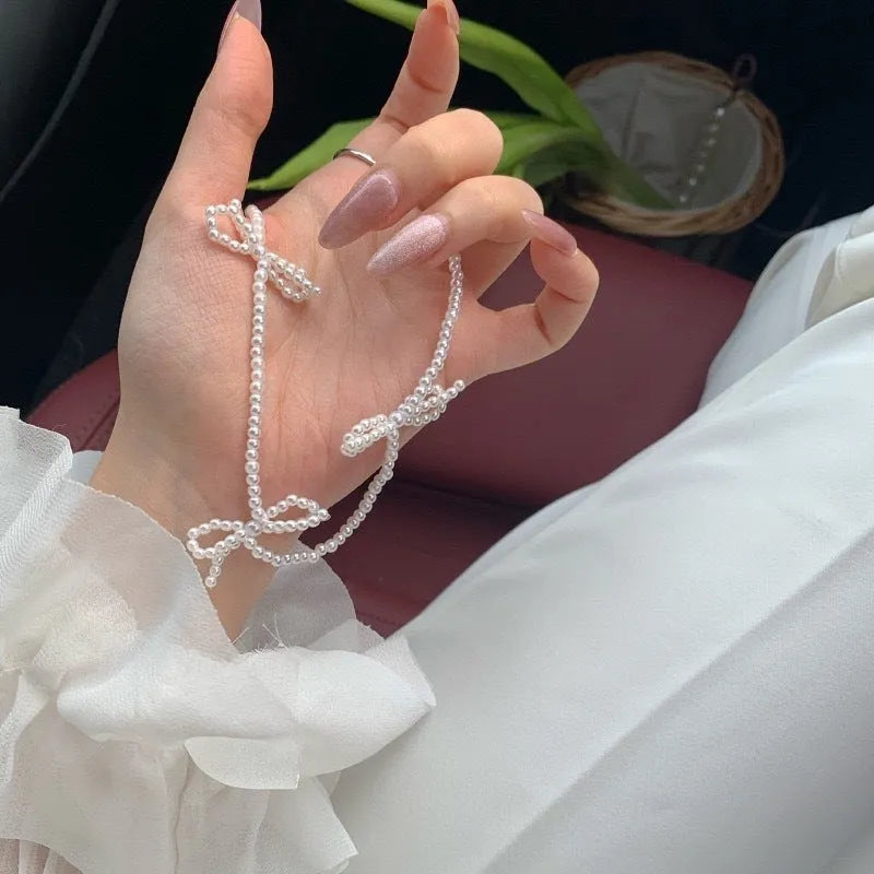 Women's white bow-shaped imitation pearl necklace with an adjustable chain.