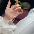Women's white bow-shaped imitation pearl necklace with an adjustable chain.