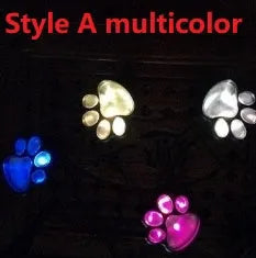 Four black animal paw print solar garden lights with stakes and one central solar panel
