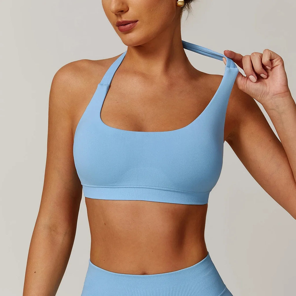 Women's black halter yoga bra with hollow design and built-in chest pads on a mannequin.