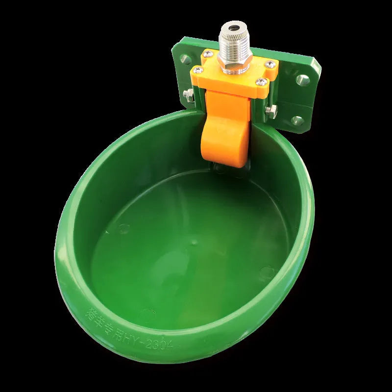Green plastic automatic water drink bowl for pigs and sheep on a farm.