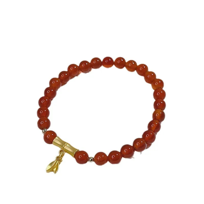 Handmade red agate women's bracelet with dragon design on a wrist.