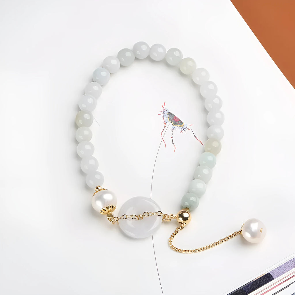 Green jade peace buckle charm and pearl beaded bracelet for women on a white background.