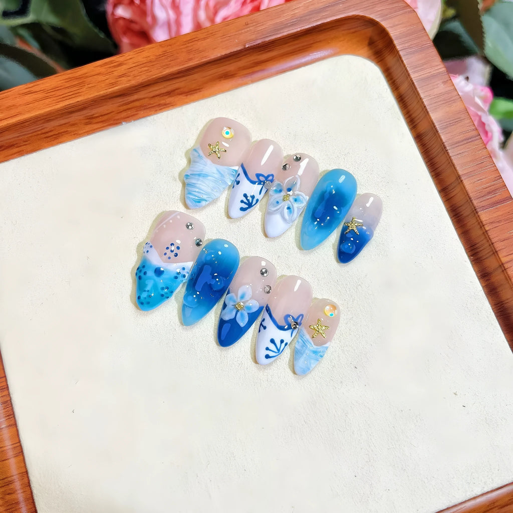 Blue summer ice transparent fake nails with hand-painted carved design, showing four size categories XS S M L