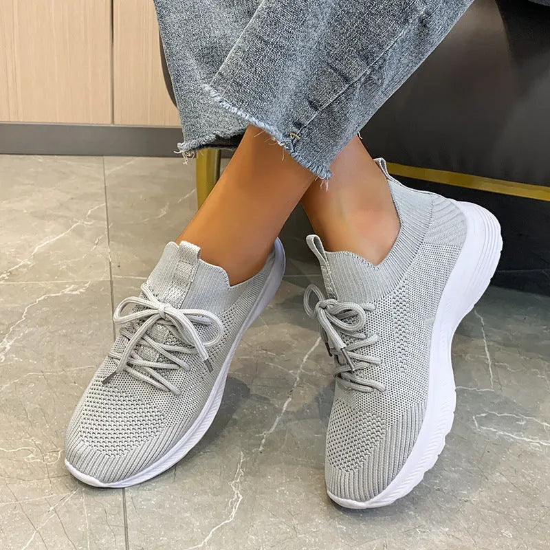 Women's low-top running shoes in creamy white with mesh and Flyknit breathable upper.