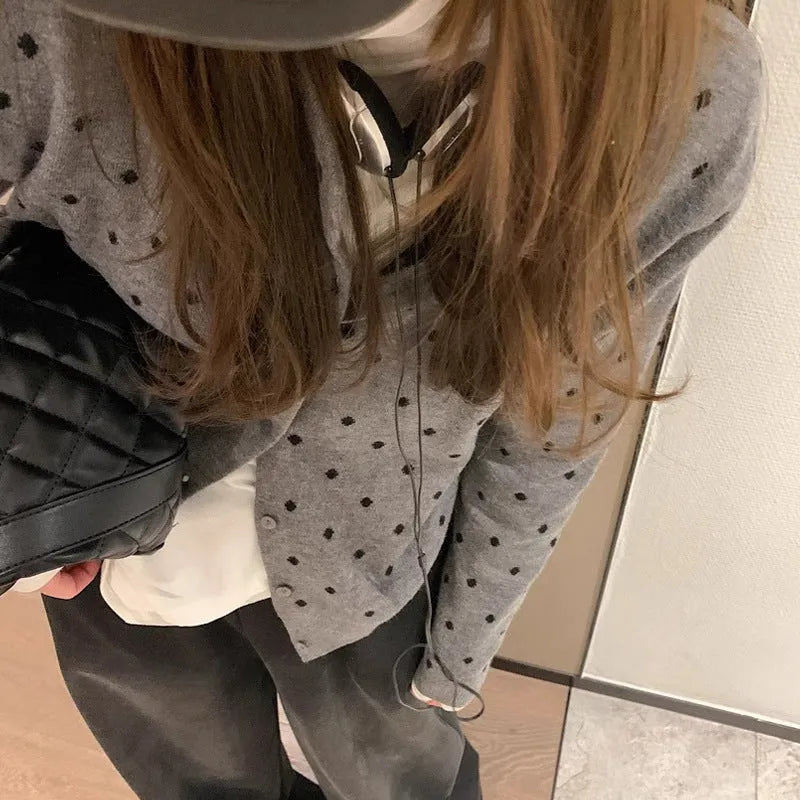 Women's grey knitted cardigan with long sleeves and white crocheted flower details on the front.