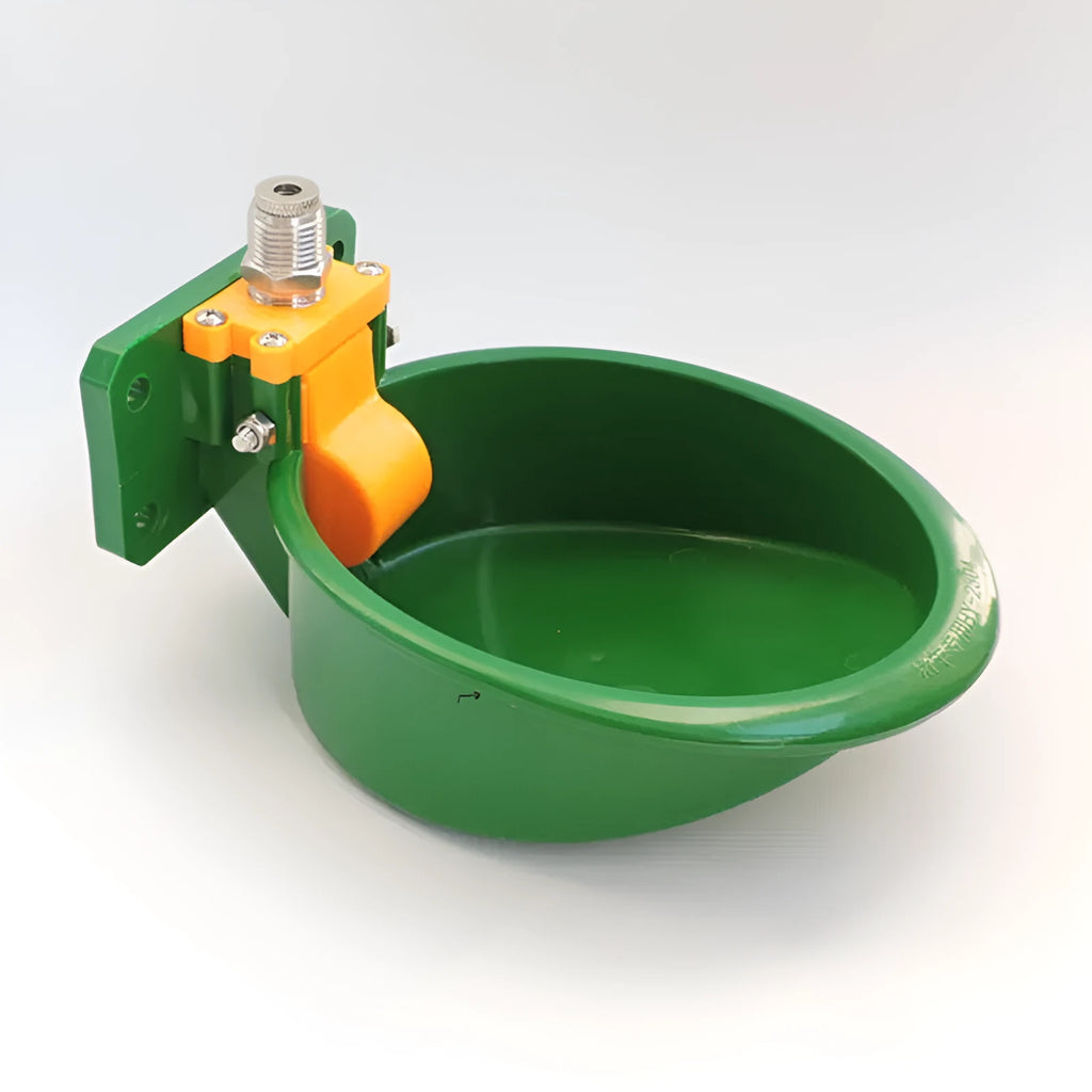 Green plastic automatic water drink bowl for pigs and sheep on a farm.