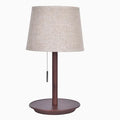 Walnut-coloured solid wood desk lamp with a white fabric shade on a wooden table.