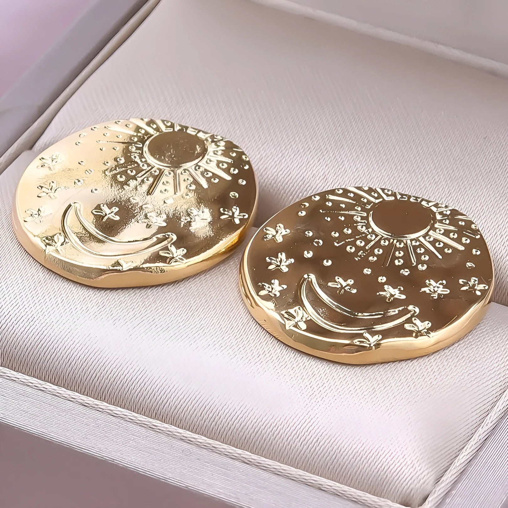 Pair of geometric stud earrings with shell design in gold or silver finish on a white background.