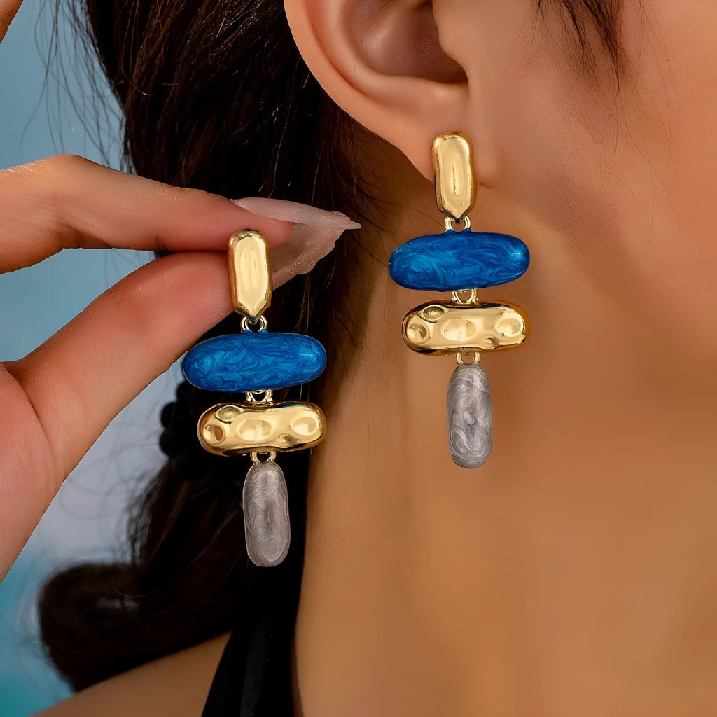Gold-electroplated zinc alloy geometric stud earrings on a plain background.