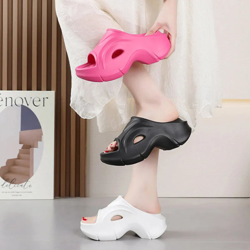 White women's EVA slippers with thick sole and round toe on a beach background.