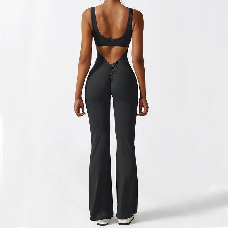 Woman wearing a sleeveless army green flare-leg jumpsuit for yoga or casual wear.