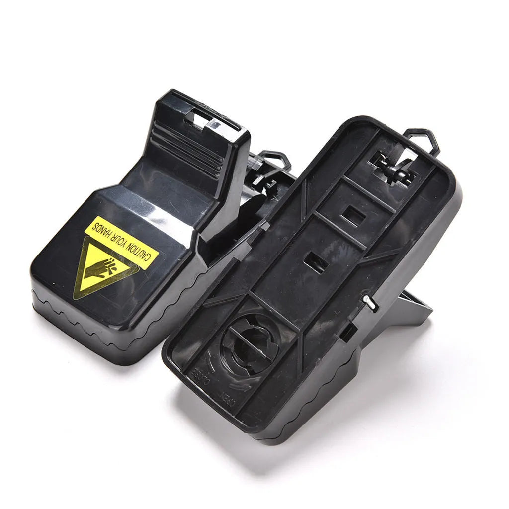 Six black plastic snapping mousetraps with set triggers on a white background.