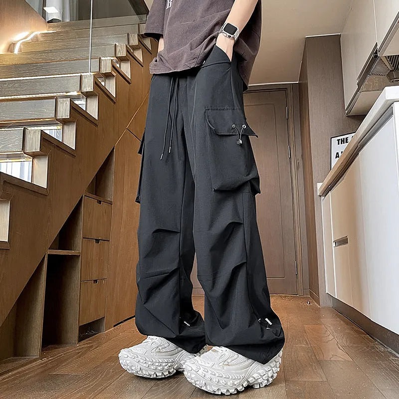 Men's plus size waterproof trousers in black, showing straight-leg fit and drawstring waist