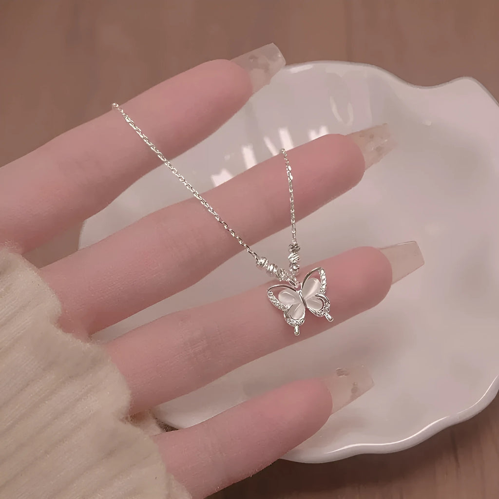 Silver butterfly pendant necklace with opal detail on cross chain