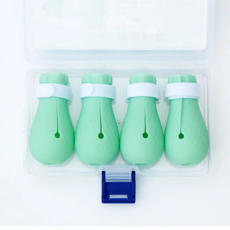 Four green silicone cat scratch prevention foot covers with an adjustable strap laid flat