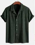 Man wearing a loose green short-sleeve cardigan-style beach shirt made from cotton and linen.