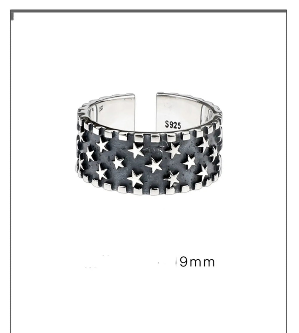 Adjustable sterling silver ring showing a geometric multi five pointed star pattern on the band.