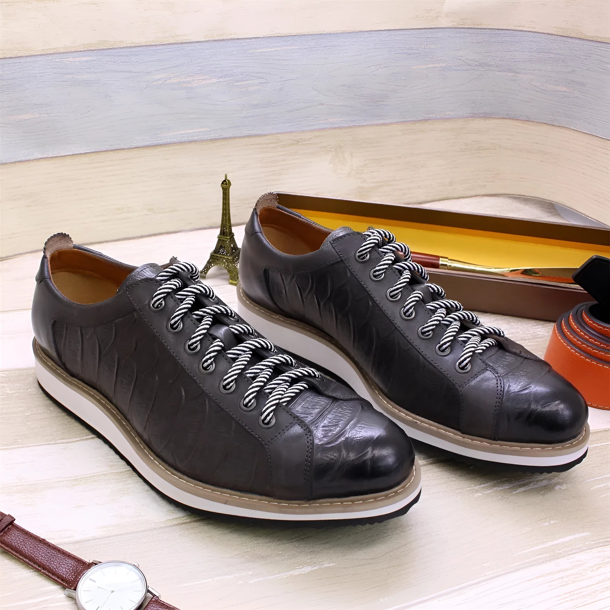 Men's low-top handmade shoes with embossed pattern and front-tie laces.