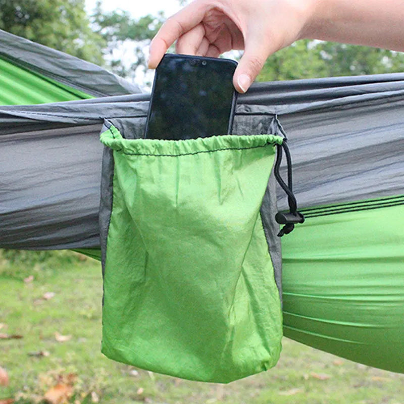 Large blue outdoor hammock made from parachute nylon fabric hanging between trees