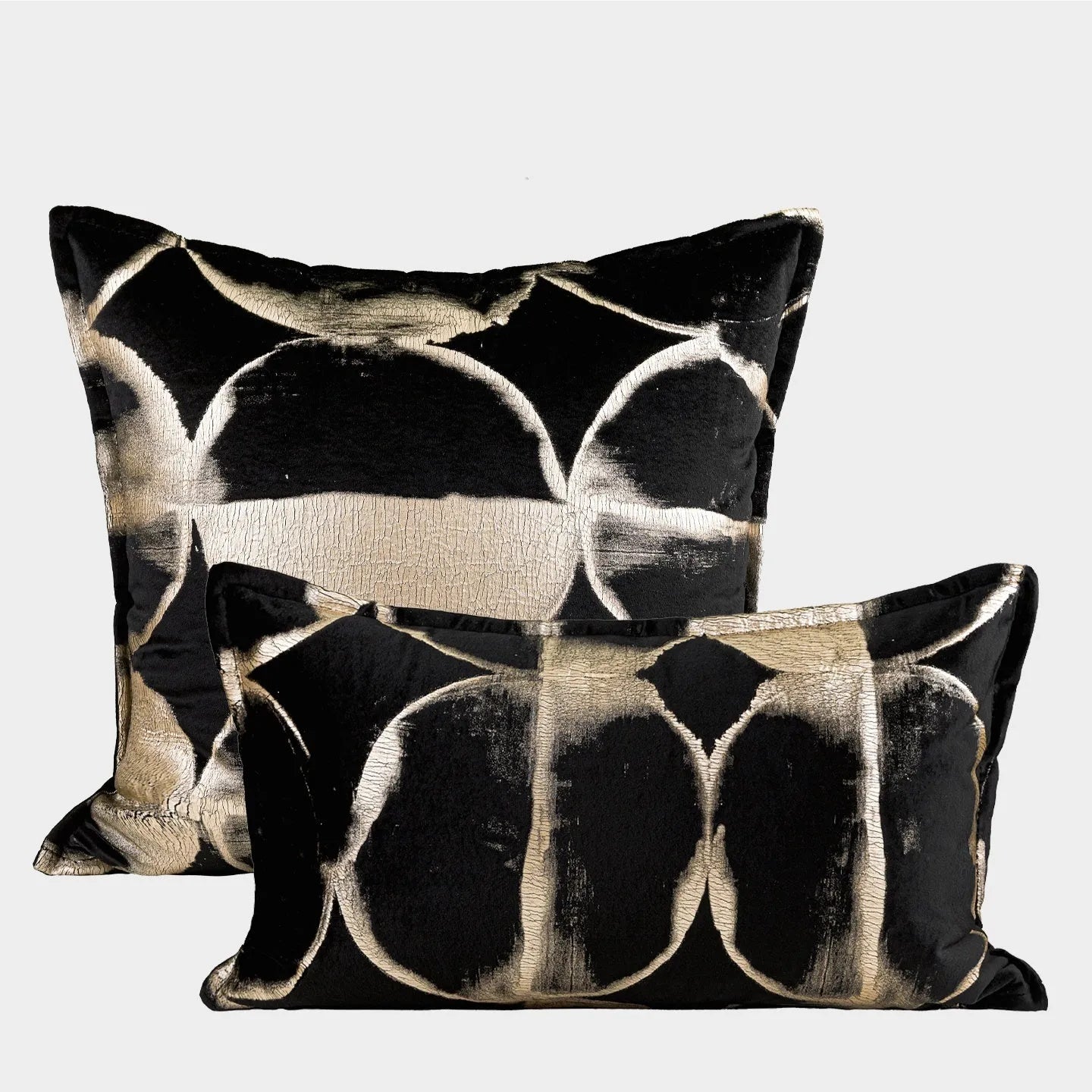 Black and gold abstract pattern flannel pillow cover on a grey sofa.
