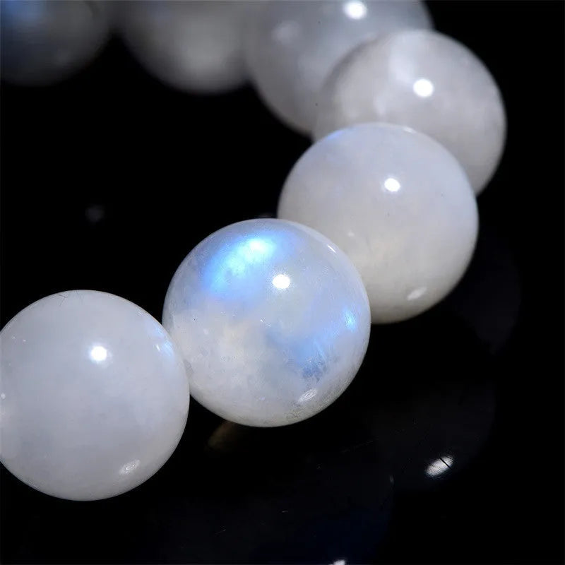 Natural blue moonlight round moonstone bead bracelet on a white background showing polished spherical beads.