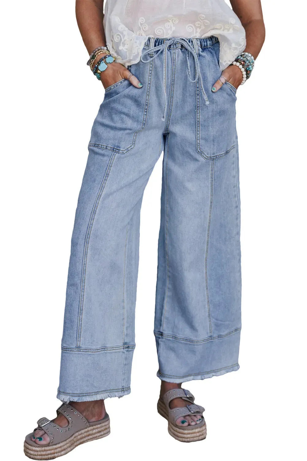 Beau blue women's wide leg denim trousers with a drawstring waistband and raw hem detail laid flat.