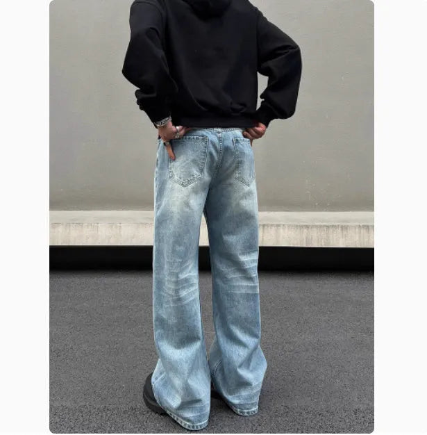 Men's blue straight leg jeans with a retro whisker wash, showing flared leg and visible stitching.