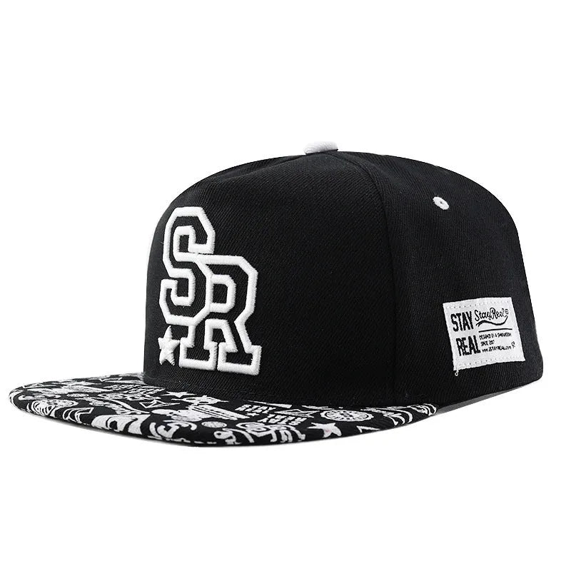 Black and white cotton baseball cap with letter embroidery on the front, showing adjustable strap.