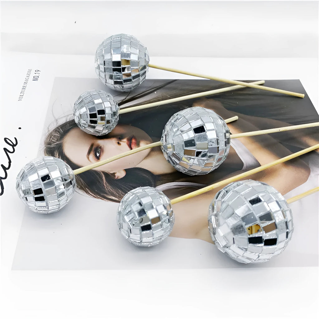 Glass disco ball cake decoration on a wooden stick, shown in different sizes.