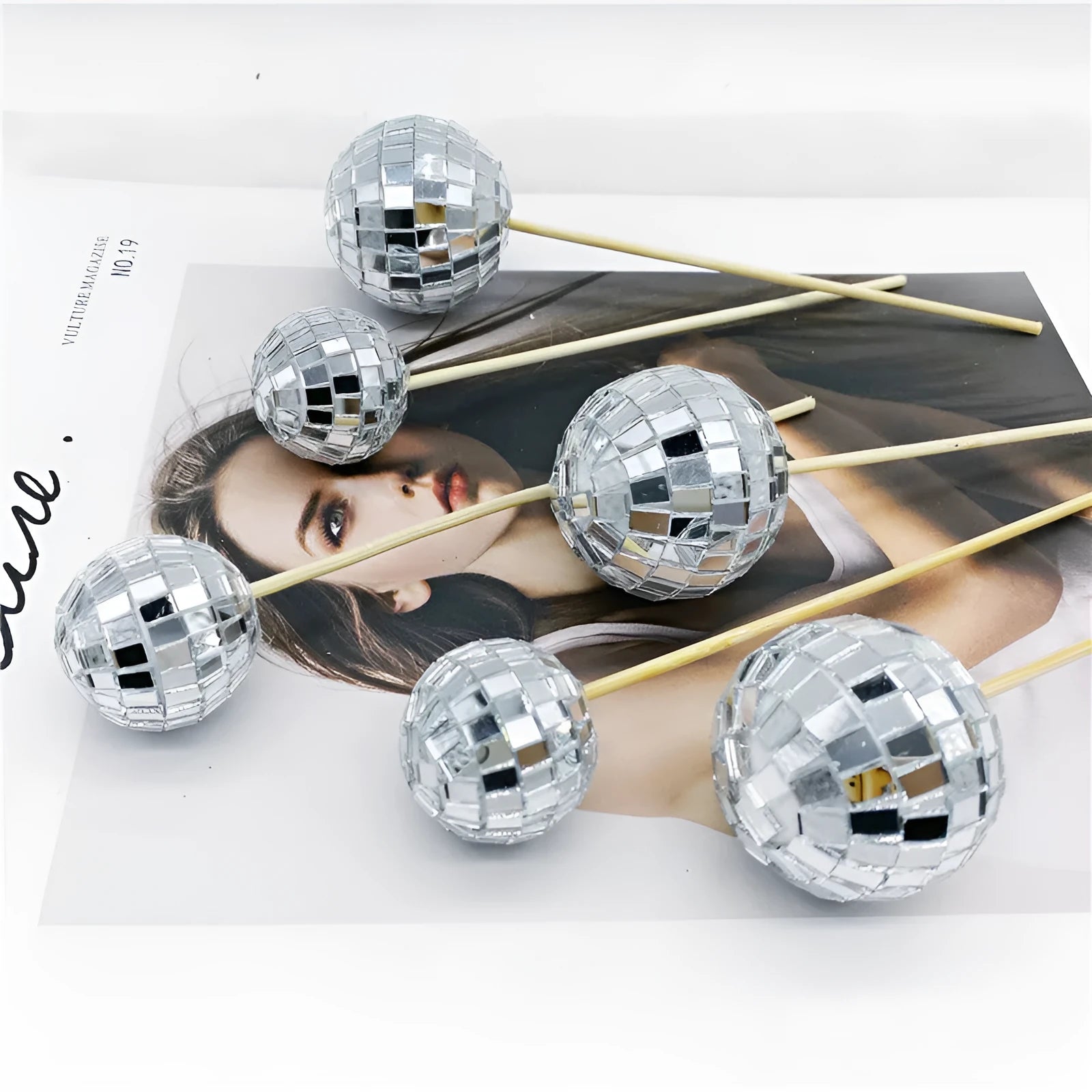 Glass disco ball cake decoration on a wooden stick, shown in different sizes.