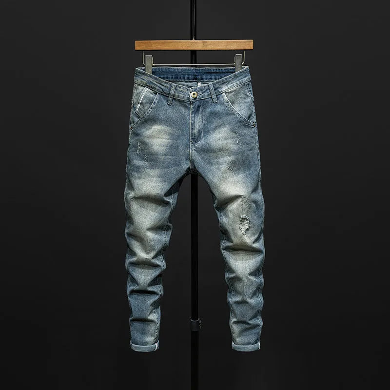 Men's slim-fit skinny jeans in dark blue denim laid flat, showing front design and button fly.