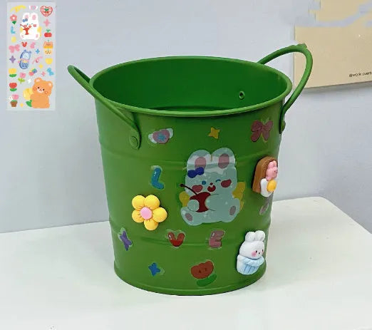 Round metal desk pen holder in a choice of colours, some with decorative sticker patches, for student stationery organisation.
