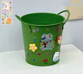 Round metal desk pen holder in a choice of colours, some with decorative sticker patches, for student stationery organisation.