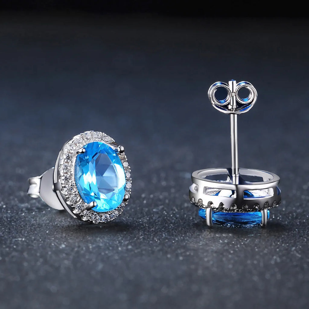 Four-piece sterling silver jewellery set with blue topaz stones including geometric earrings, ring, bracelet and necklace