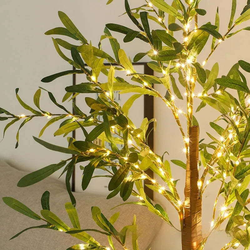 1.8 metre tall artificial olive leaf tree with warm white LED lights illuminated in a garden setting.
