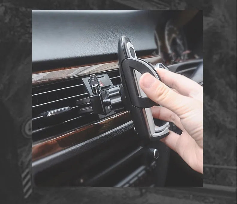 Black plastic mobile phone holder mounted on car air conditioning vent