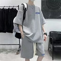 Man wearing a grey waffle-textured short sleeve top and matching shorts from the leisure sports suit set.
